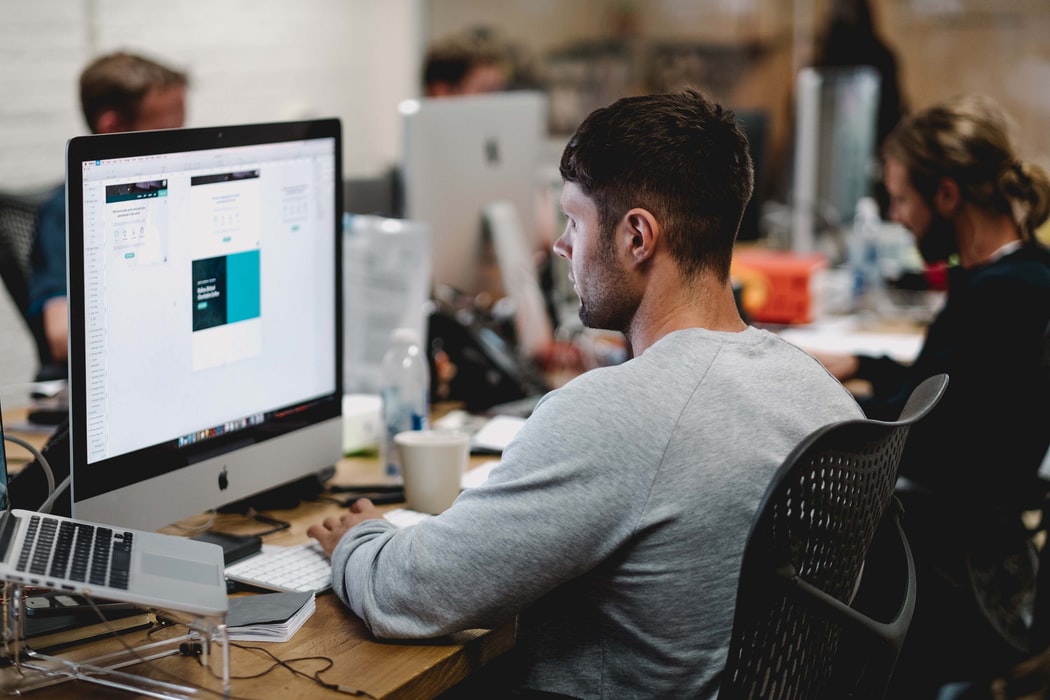 A guy designer working with imac