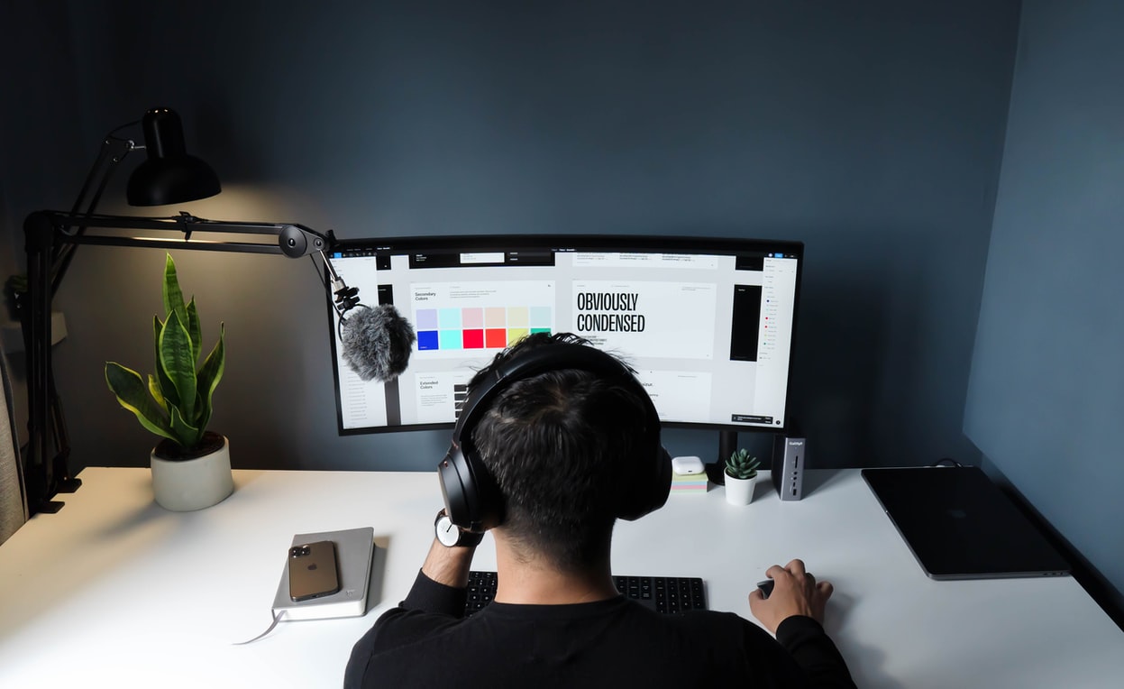 A boy with headphones working with computer