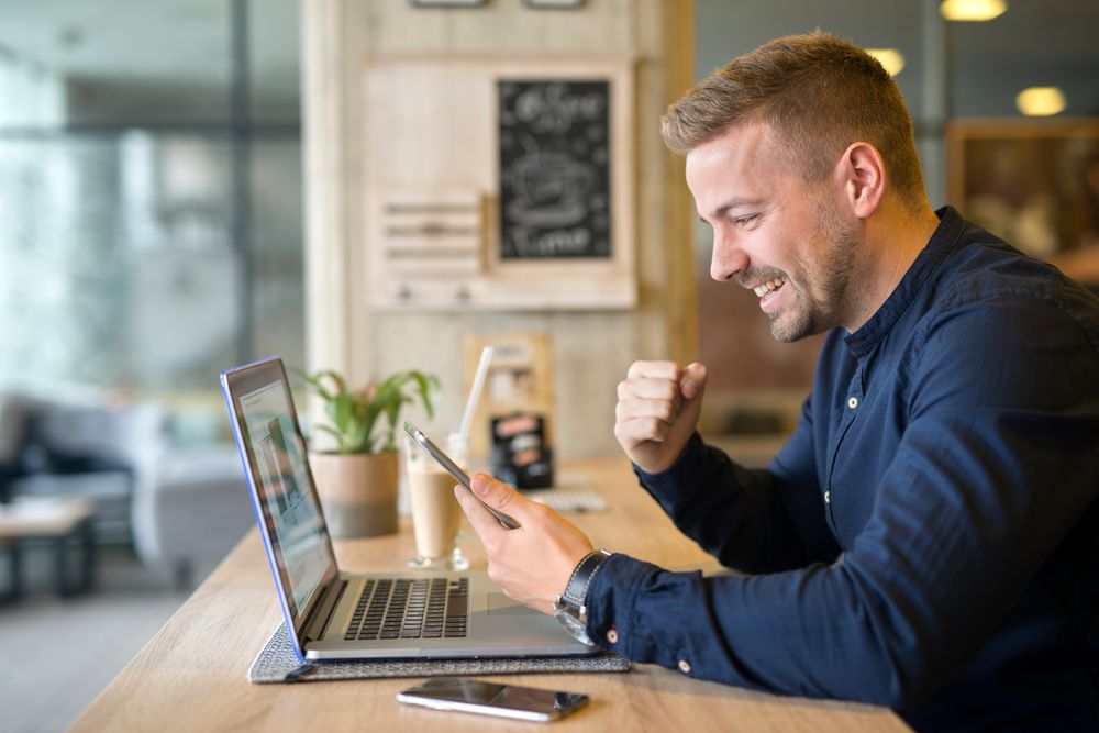 A man watching computer and smartphone