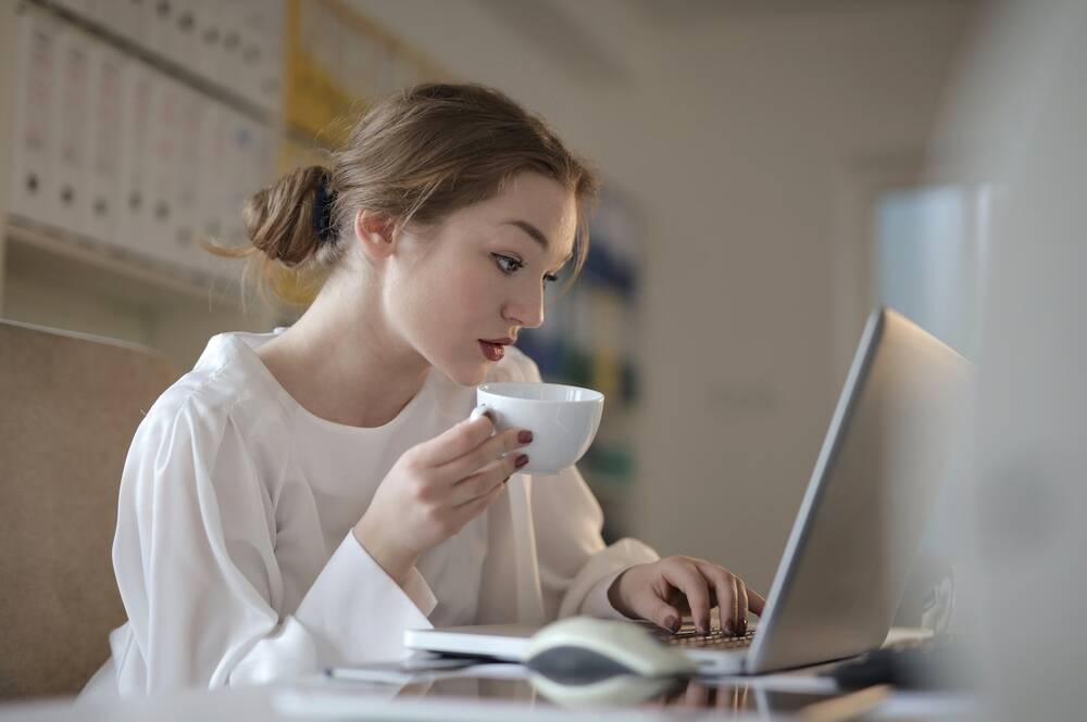 Girl drink coffee and use social media in laptop